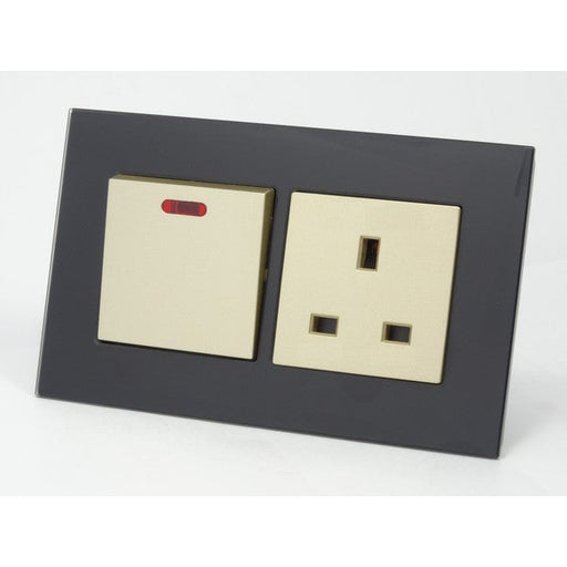black glass double frame with gold modules of a  switch and a UK socket